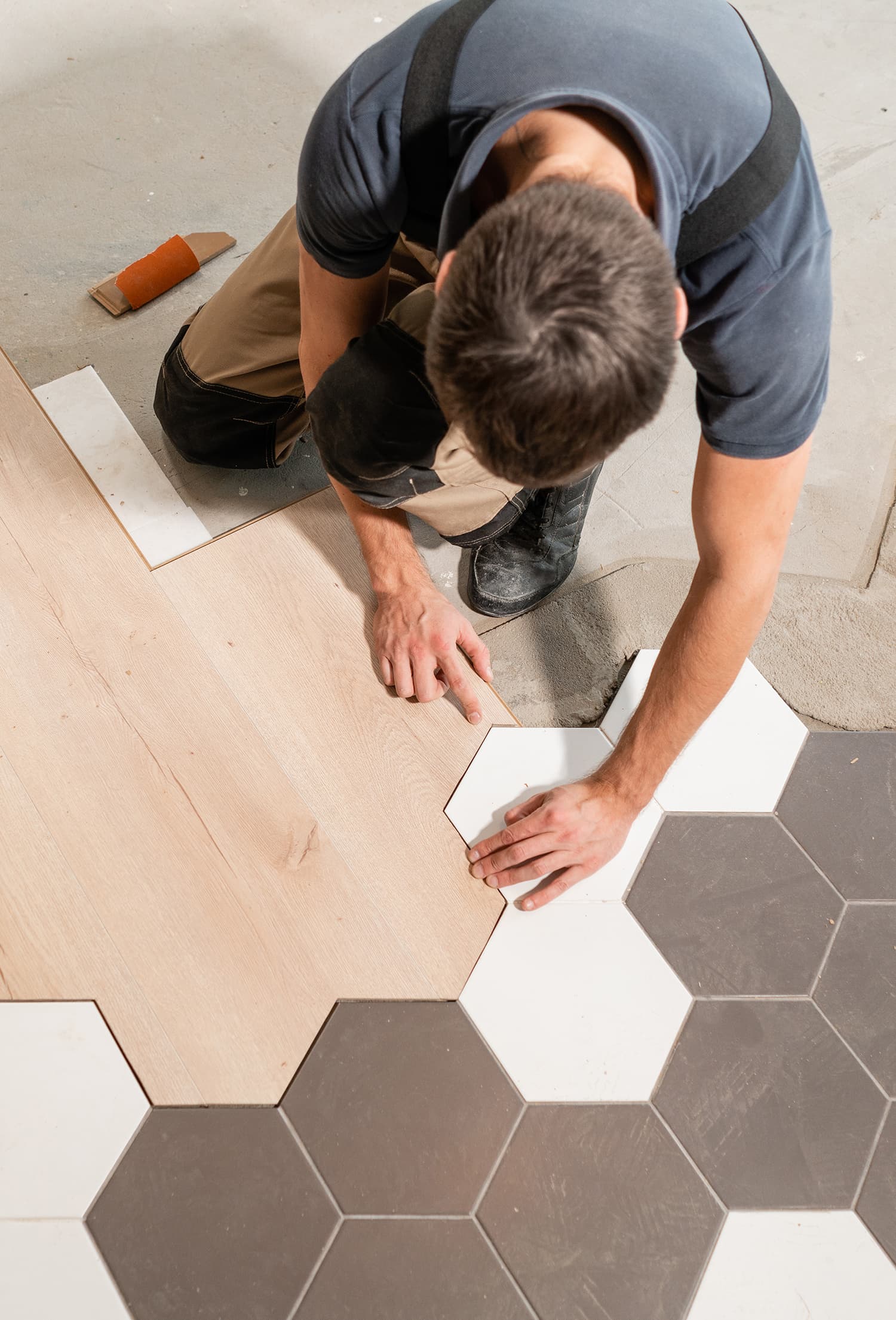 Male worker installing new wooden laminate flooring