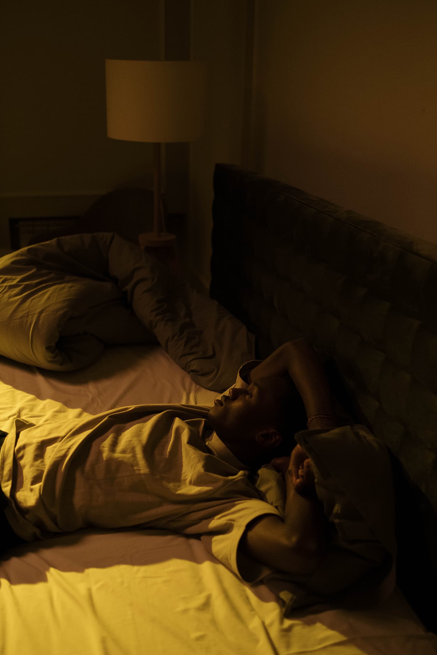 A Man Sitting on the Bed in a Dark Room